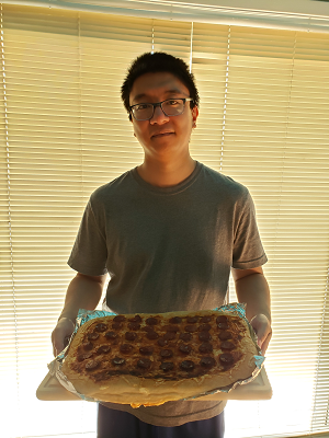 Photo of the website author Tony Pham holding a fresh out of the oven Phamtastic Pizza